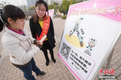 資料圖：今年3月8日，安徽合肥新華社區(qū)志愿者夏一瓊(右)向市民普及反家暴相關(guān)法律知識(shí)。鐘欣 攝